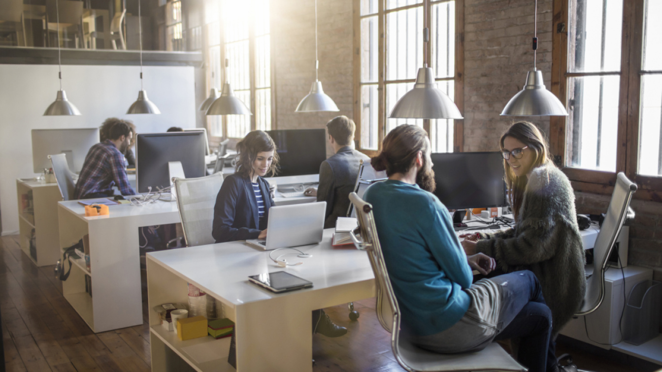 Group of young people working in a modern open plan office