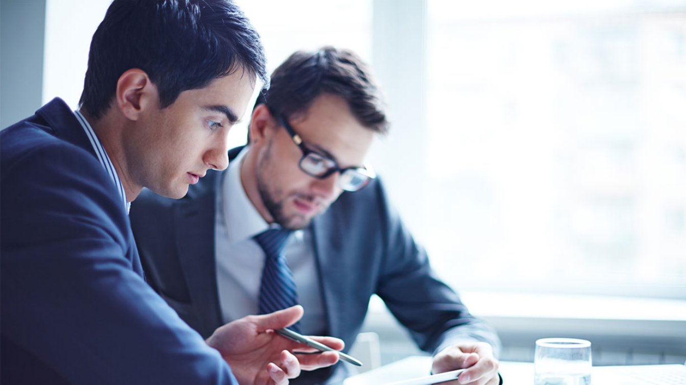 Two men sitting together talking about Business.